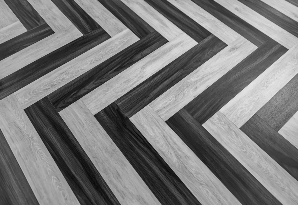 Herringbone pattern flooring in alternating light and dark wood planks creating diagonal chevron design.